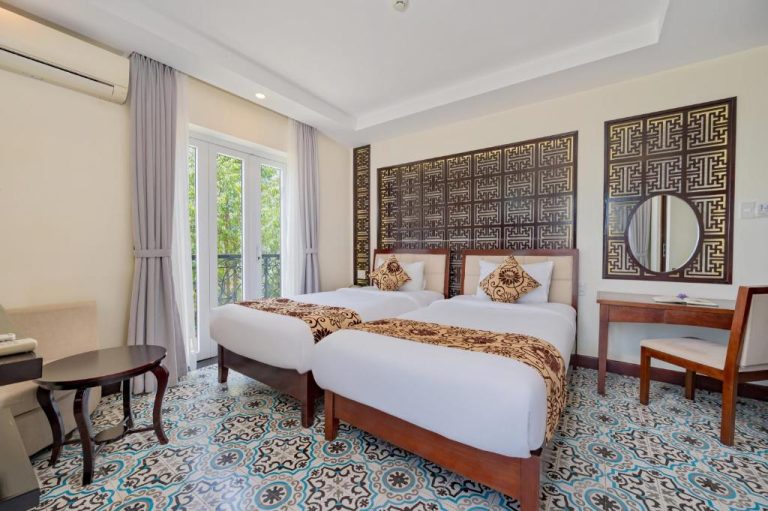 Habitación twin con dos camas y decoración tradicional vietnamita en Hoi An Canal House Riverside By Haviland