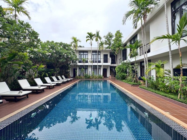 Piscina exterior con tumbonas y jardín tropical del hotel The Bliss Angkor en Siem Reap