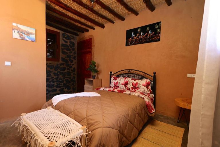 Habitación doble de estilo rústico marroquí con techo de madera y decoración tradicional en Palais D'orient