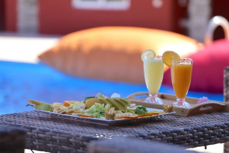 Bandeja con frutas tropicales y zumos frescos junto a la piscina del Palais D'orient