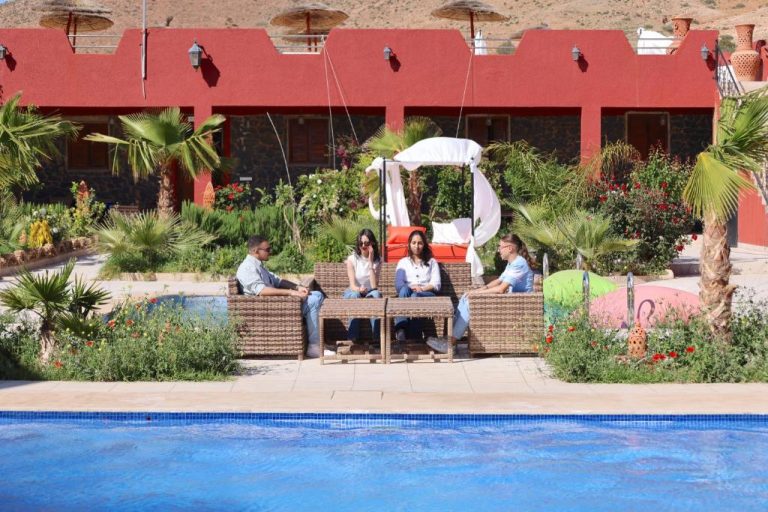 Turistas relajándose junto a la piscina exterior con tumbonas y jardín tropical del Palais D'orient