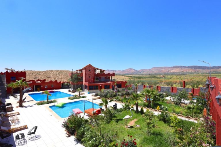 Piscina exterior con jardín tropical y vistas a la montaña del Palais D'orient en Marruecos