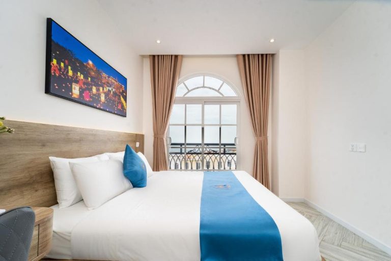 Habitación doble con cama king y ventana arqueada con vistas al mar en Novus Sol Hotel Phu Quoc