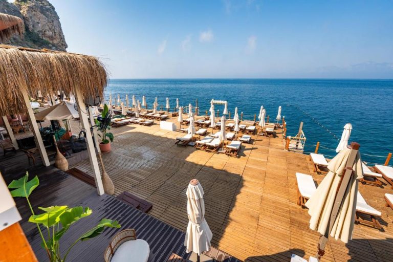 Terraza solarium con tumbonas y sombrillas frente al mar Mediterráneo en Massimo Hotel Adults Only