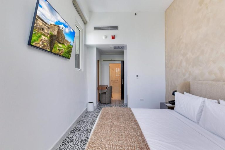 Habitación doble moderna con cama king y TV en pared del Hotel Milano, decoración contemporánea