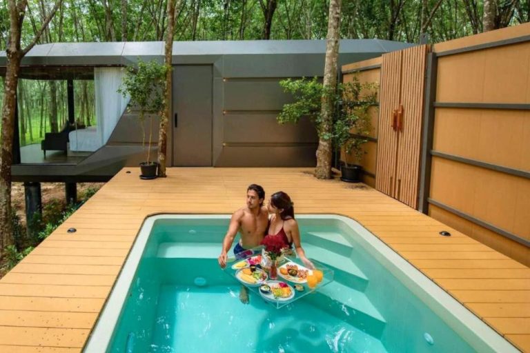 Pareja disfrutando de la piscina privada con desayuno flotante en Timber Society Boutique Hideaway