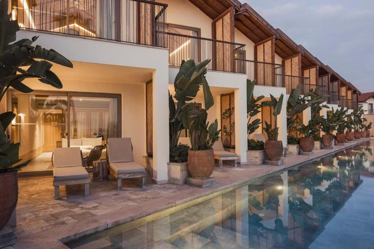 Piscina exterior con tumbonas y habitaciones con terraza del Day One Beach Resort & SPA Adult Only