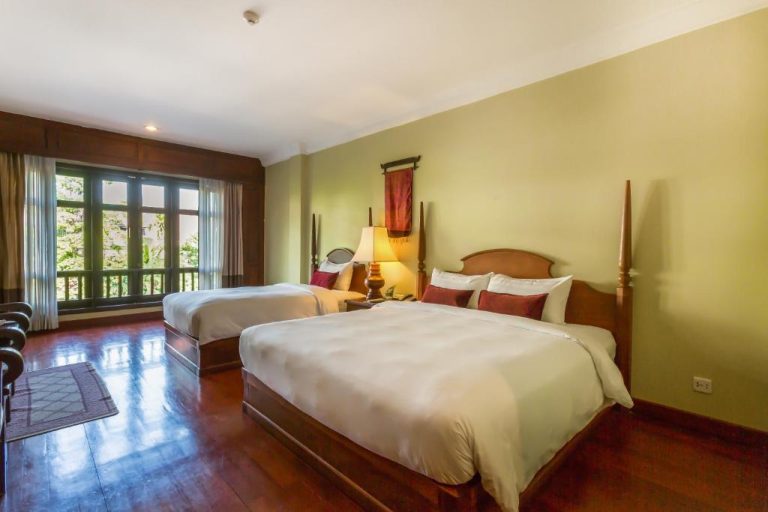 Habitación doble con camas de madera y suelo de parqué en Prince Angkor Hotel & Spa