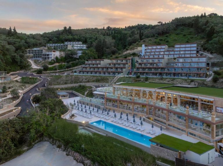 Vista aérea de la piscina exterior y terraza del hotel Mythos Panorama Adults Only entre colinas