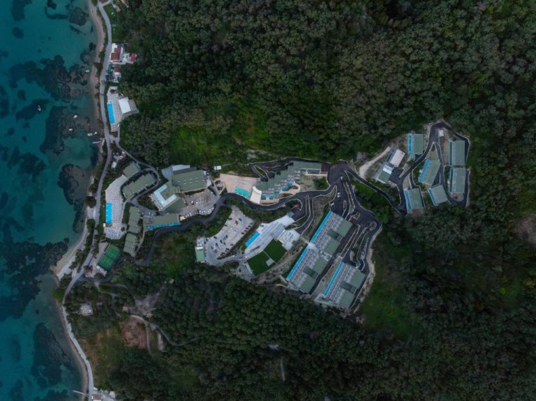 Vista aérea del resort Mythos Panorama Adults Only con piscinas y bungalows rodeados de bosque junto al mar