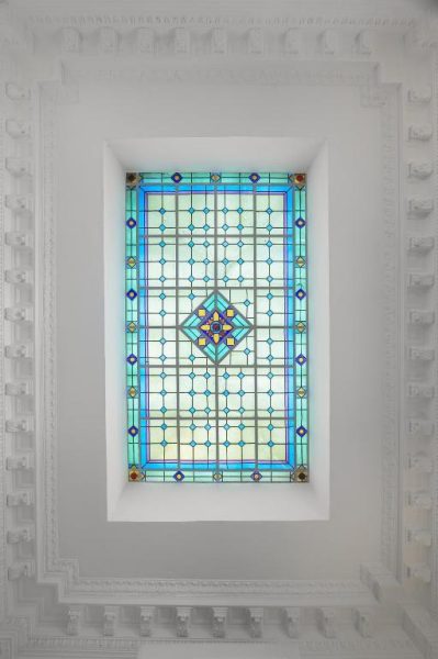 Vitral artístico con diseño geométrico en tonos turquesa del hotel FAUNA Montevideo
