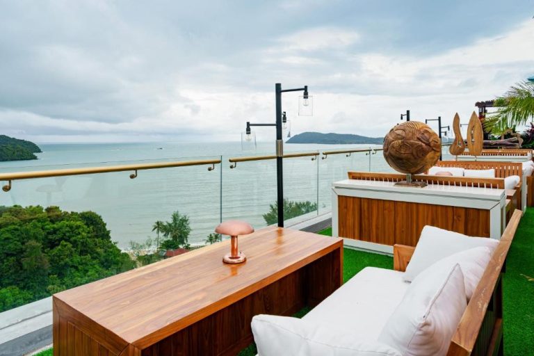 Terraza lounge con vistas al mar y mobiliario de madera en The RIYAZ Lavanya Langkawi