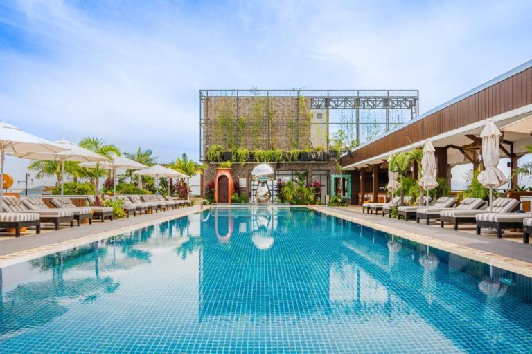 Piscina exterior con tumbonas y jardín vertical del hotel The RIYAZ Lavanya Langkawi