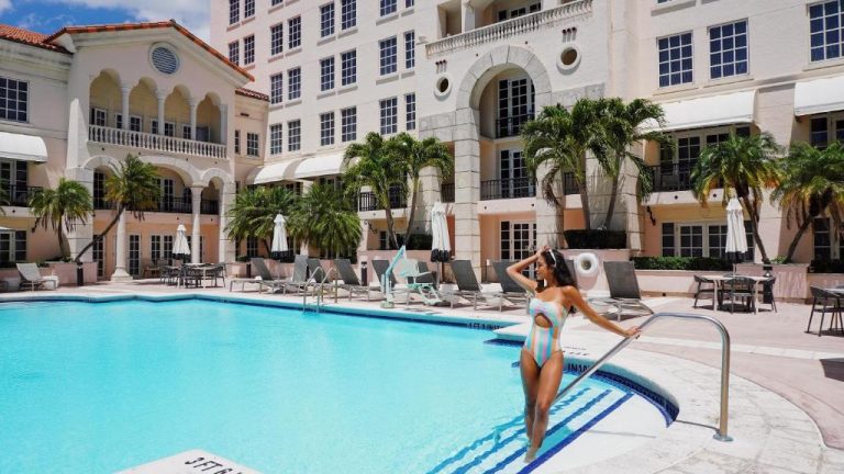 Piscina exterior del Hyatt Regency Coral Gables en Miami con tumbonas y palmeras tropicales