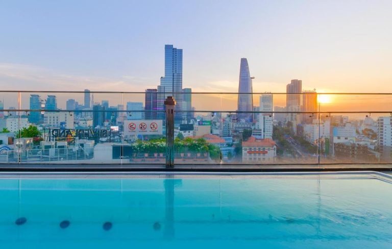 Piscina infinita en la azotea del Winsuites Saigon Hotel con vistas panorámicas al skyline de Ho Chi Minh al atardecer