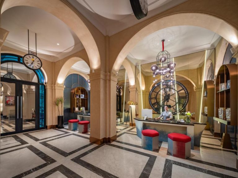 Elegante lobby con arcos coloniales y recepción del Grand Hotel du Lac Boutique Saigon