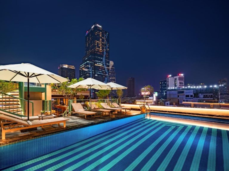 Piscina infinita en la azotea del Grand Hotel du Lac Boutique Saigon con vistas al skyline nocturno