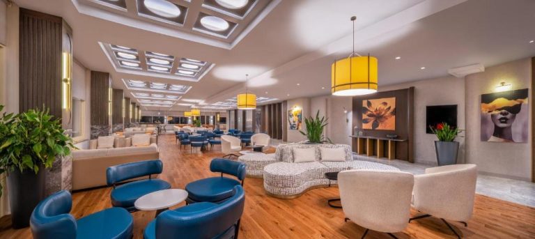 Amplio lobby lounge con sillones azules y sofás blancos del Trendy Palm Beach Adults Only