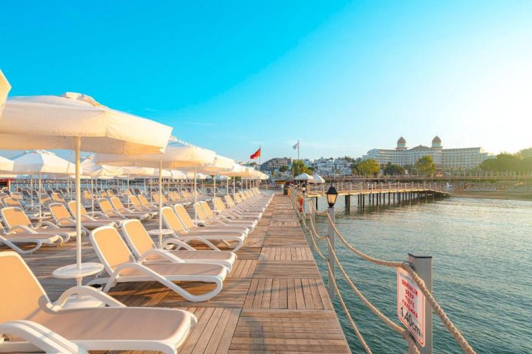 Terraza sobre el mar con tumbonas y sombrillas blancas en Sidemarin Kirman Premium Ultra All Inclusive