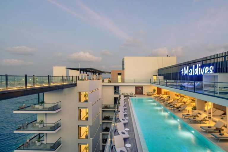 Piscina infinita en la azotea del Barceló Nasandhura Male con tumbonas y vistas panorámicas