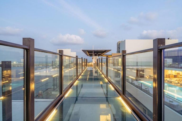 Pasarela de cristal iluminada en la azotea del Barceló Nasandhura Male con vistas a la piscina