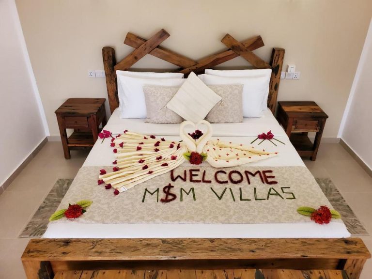Habitación con decoración de bienvenida romántica con toallas en forma de cisnes en M&M Villas Zanzibar