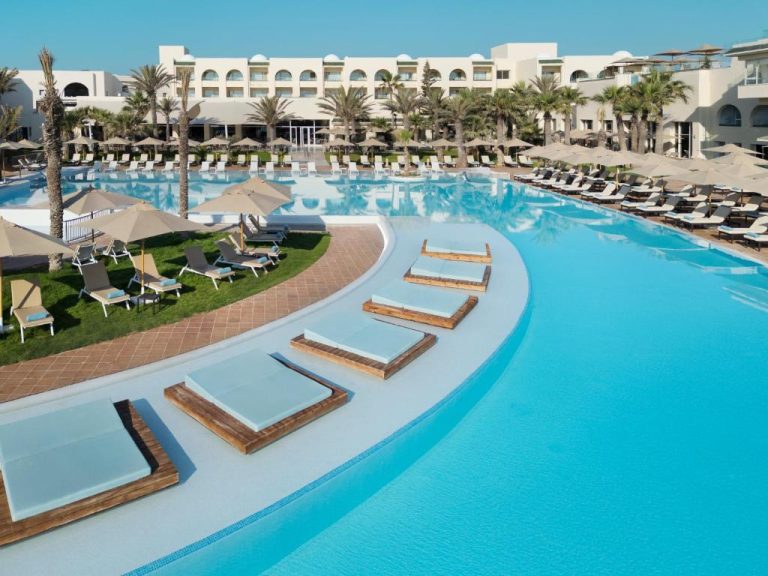 Amplia piscina exterior con tumbonas y palmeras del Iberostar Selection Eolia Djerba en Túnez