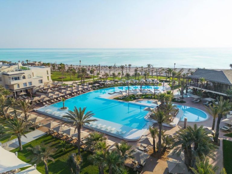 Vista aérea de la piscina exterior y playa del Iberostar Selection Eolia Djerba con palmeras y tumbonas