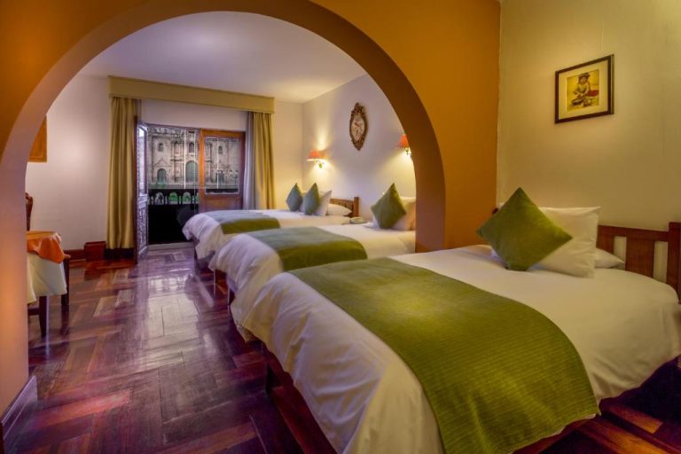 Habitación triple con camas individuales y arco decorativo en Hotel Katari Plaza Cusco El Virrey