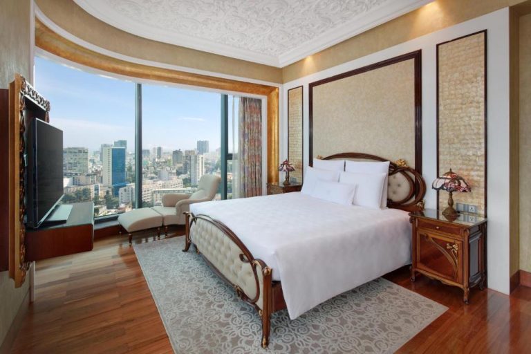Lujosa suite con cama king size y vistas panorámicas a la ciudad en The Reverie Saigon Residential Suites