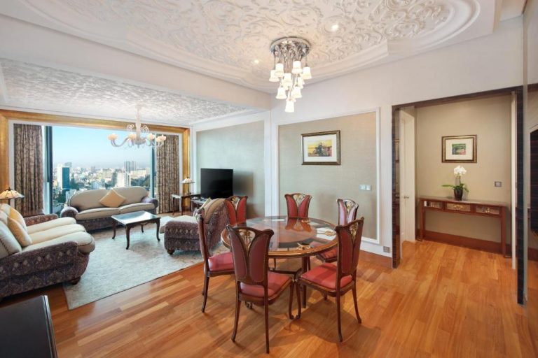 Salón comedor de lujo con suelo de madera y vistas panorámicas a la ciudad en The Reverie Saigon