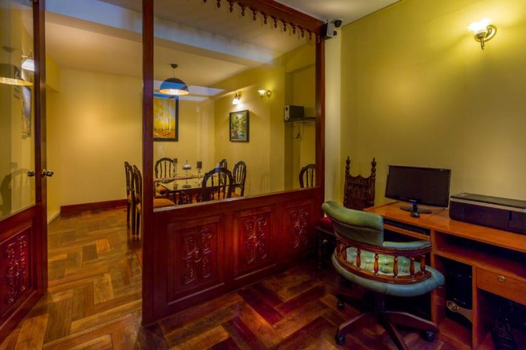 Área de trabajo con computadora y comedor colonial en Hotel Katari Plaza Cusco El Virrey