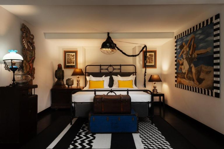 Habitación de estilo colonial con cama de hierro forjado y decoración vintage en Shinta Mani Angkor
