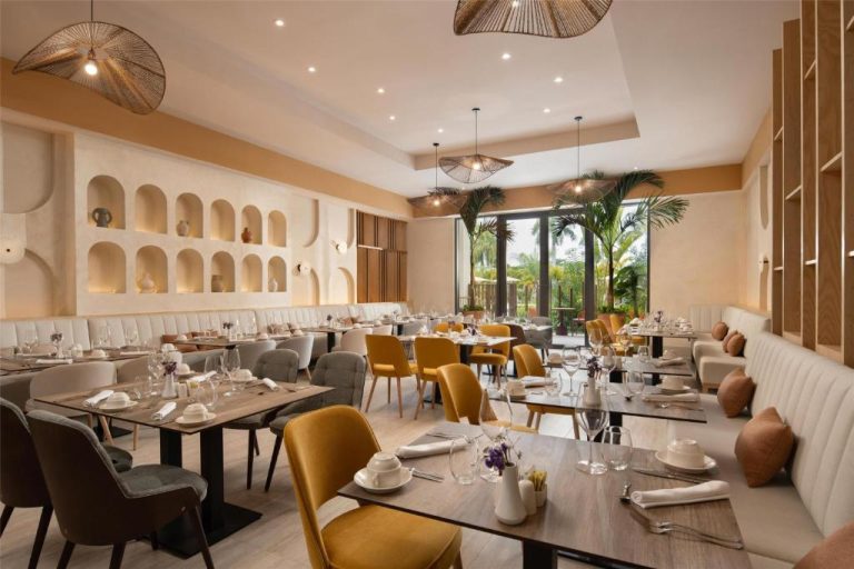 Elegante restaurante interior del Royal Beach Hotel Punta Cana con sillas doradas y decoración tropical