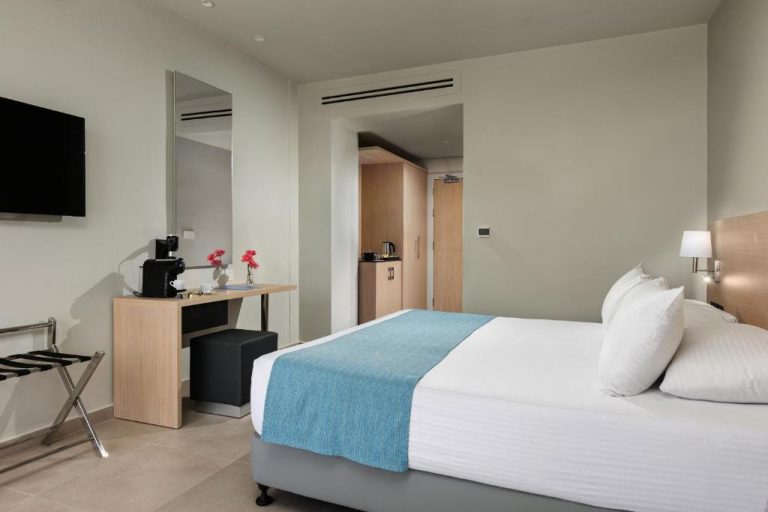 Habitación doble con cama matrimonial y escritorio en el Mayfair Hotel, decoración moderna en tonos neutros