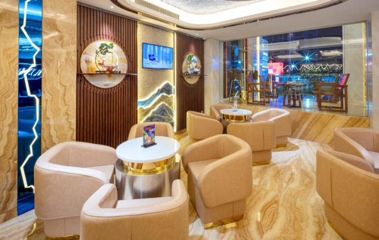 Elegante lobby lounge del Winsuites Saigon Hotel con sillones beige y mesas doradas en Ho Chi Minh