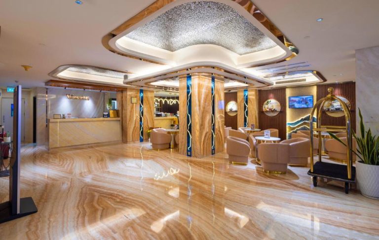 Lujoso lobby con suelo de mármol y decoración dorada del Winsuites Saigon Hotel en Vietnam