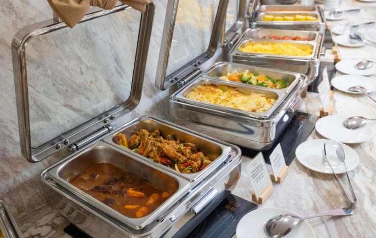 Buffet de desayuno con variedad de platos calientes en chafing dishes del Winsuites Saigon Hotel