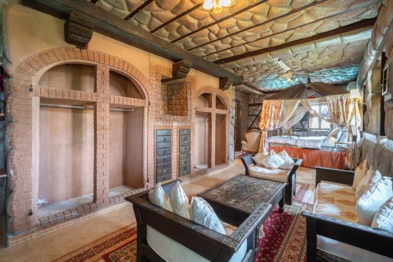Suite rústica con arcos de ladrillo, cama con dosel y zona de estar en Lakala Complexe Touristique