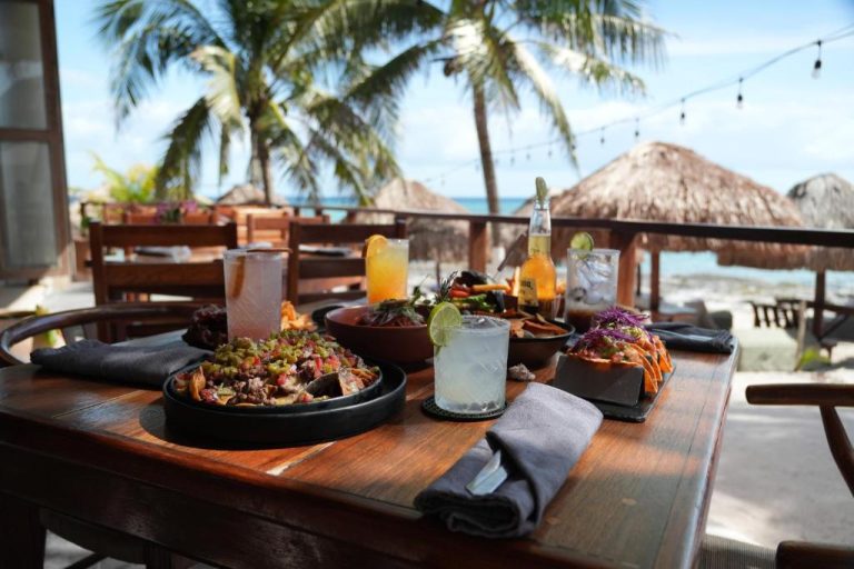 Mesa con tacos y bebidas tropicales en el restaurante frente al mar del Paamul Hotel en México