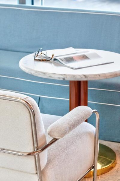 Elegante zona lounge con silla blanca y mesa de mármol en el Mr C Miami Coconut Grove