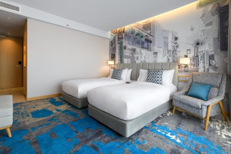 Habitación doble con mural urbano y alfombra azul en el hotel OZO George Town Penang