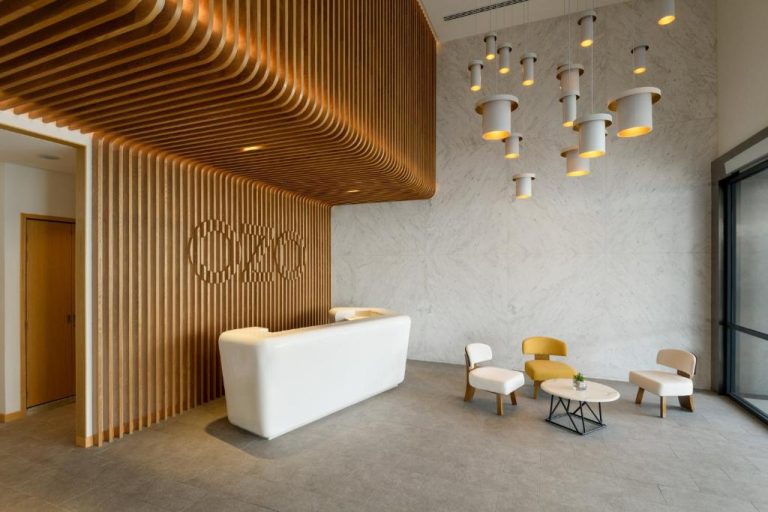 Recepción moderna con diseño en madera y zona de espera del hotel OZO George Town Penang