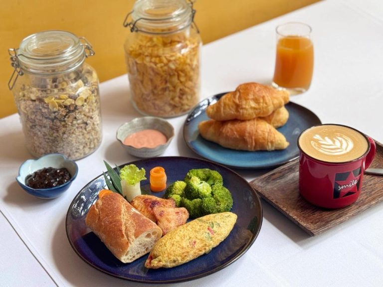 Desayuno completo con croissants, tortilla, brócoli, granola y café latte en The Bliss Angkor