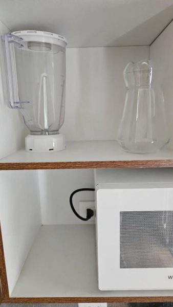 Cocina equipada con licuadora, jarra de vidrio y microondas blanco en Altamira Apart Suites