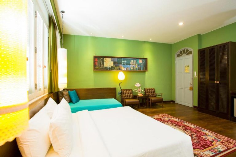 Habitación doble con paredes verdes y decoración colonial en The Memory at On On Hotel Phuket