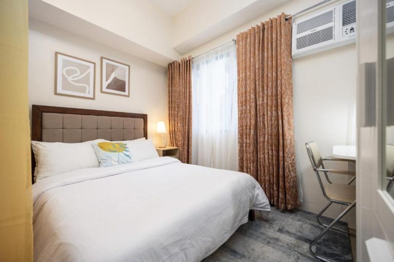Habitación doble con cama matrimonial y escritorio en LD Cozy Condo Unit cerca de Cebu IT Park