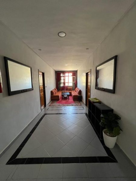Pasillo principal con salón de estar y sofás rojos en el Hotel BananaHouse