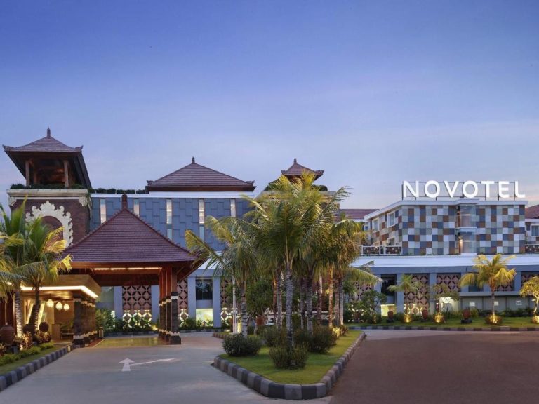 Fachada exterior del Novotel Bali Ngurah Rai Airport con arquitectura balinesa y palmeras al atardecer