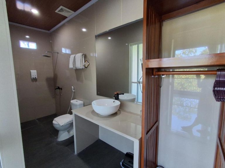 Baño moderno con lavabo redondo, ducha y espejo amplio en L'Javas Villas